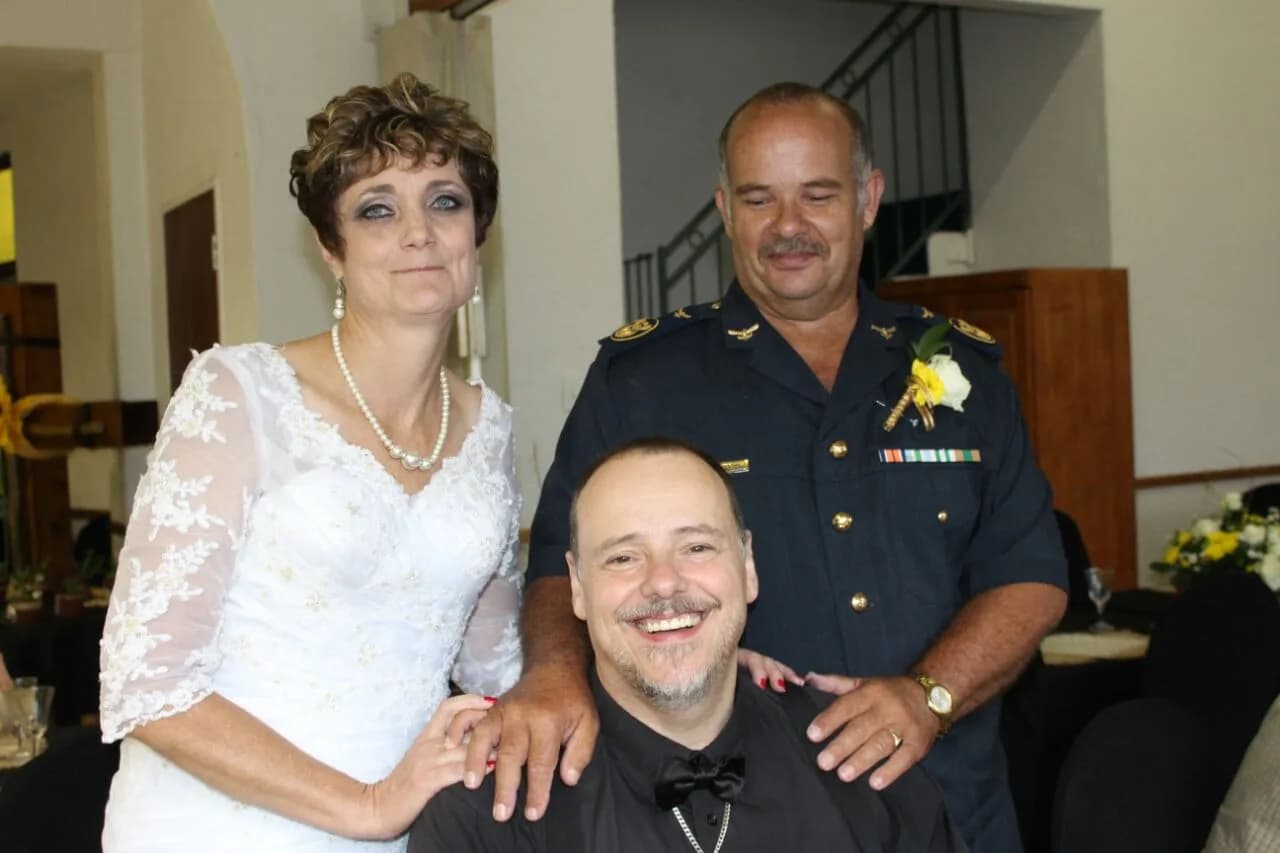 Dr Heinrich Lottering with a married couple at their wedding reception